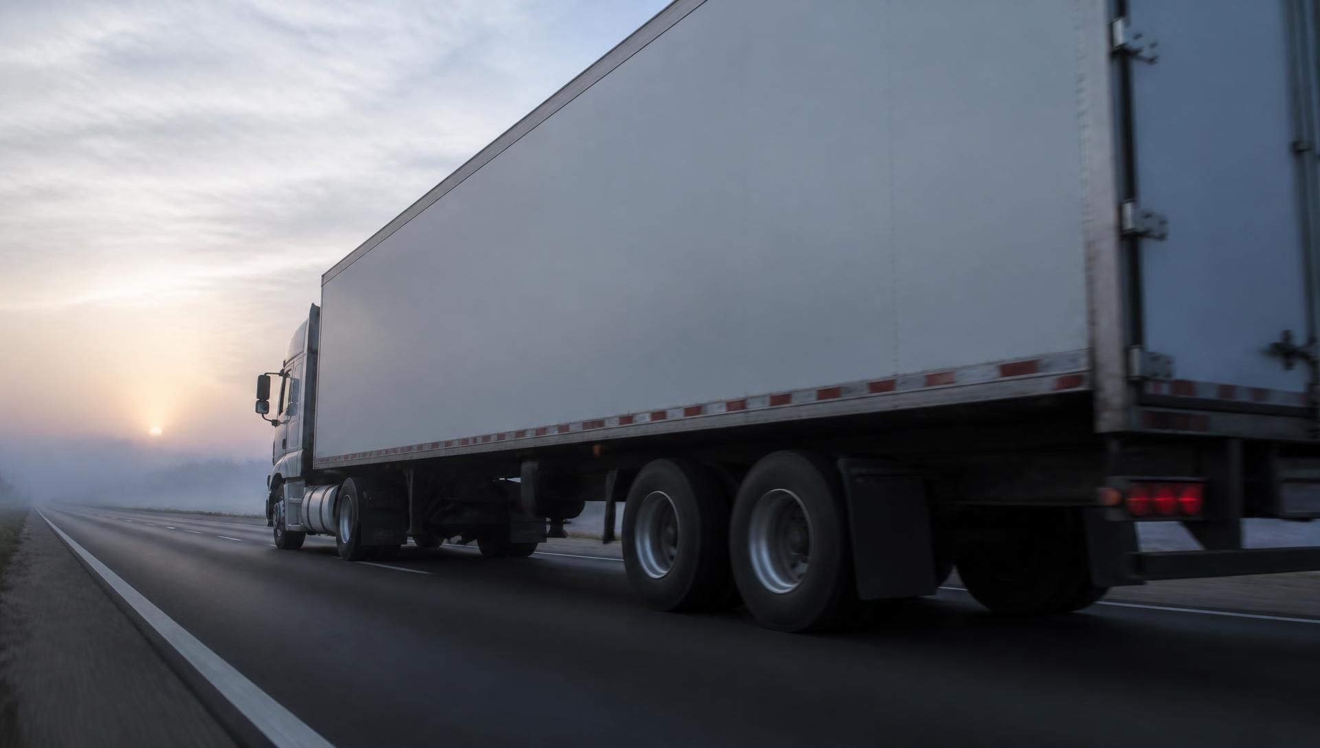 Camion de déménagement sans marquage sur une autoroute à l’aube